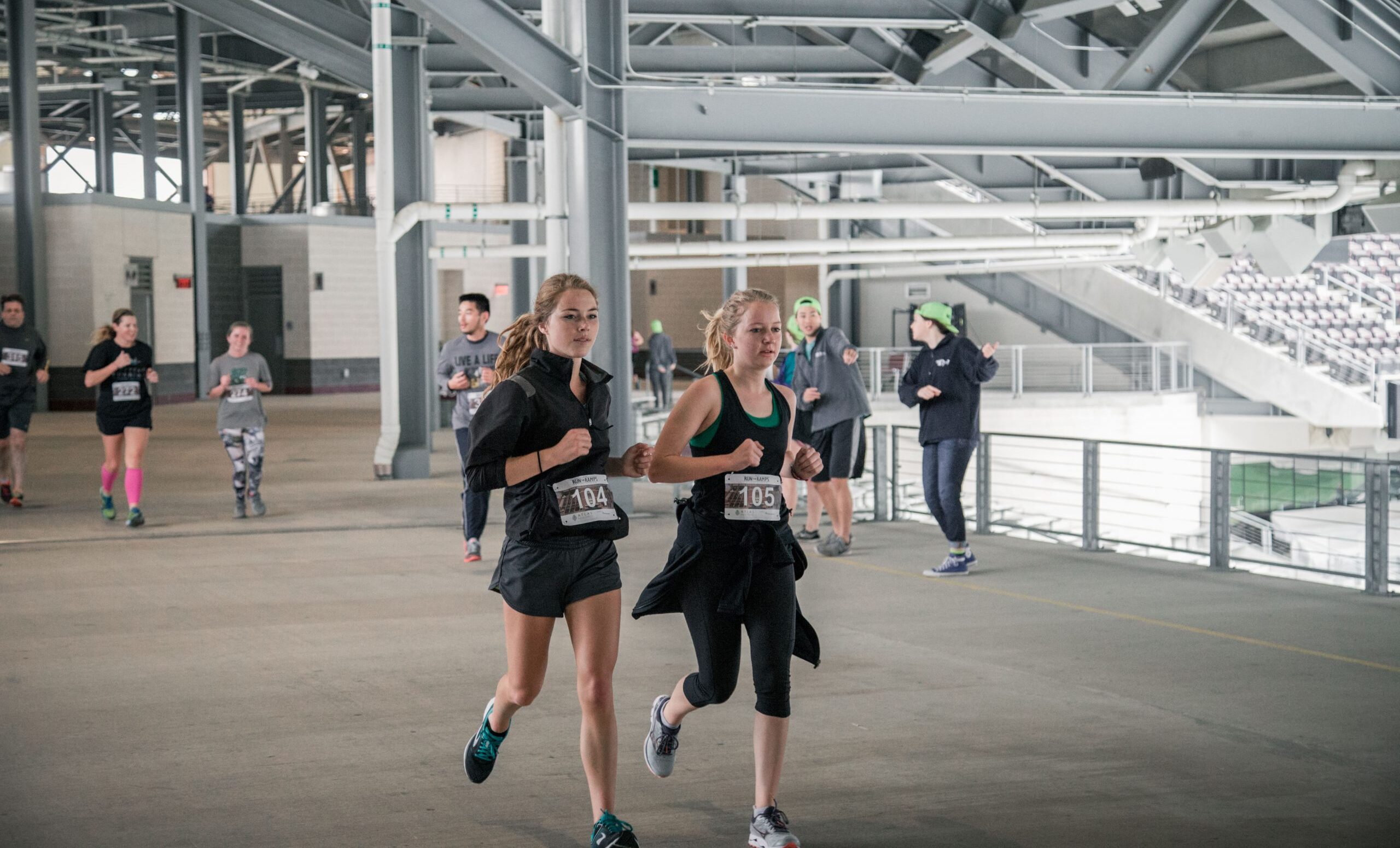Two participants of the Run the Ramps event running in Kyle Field