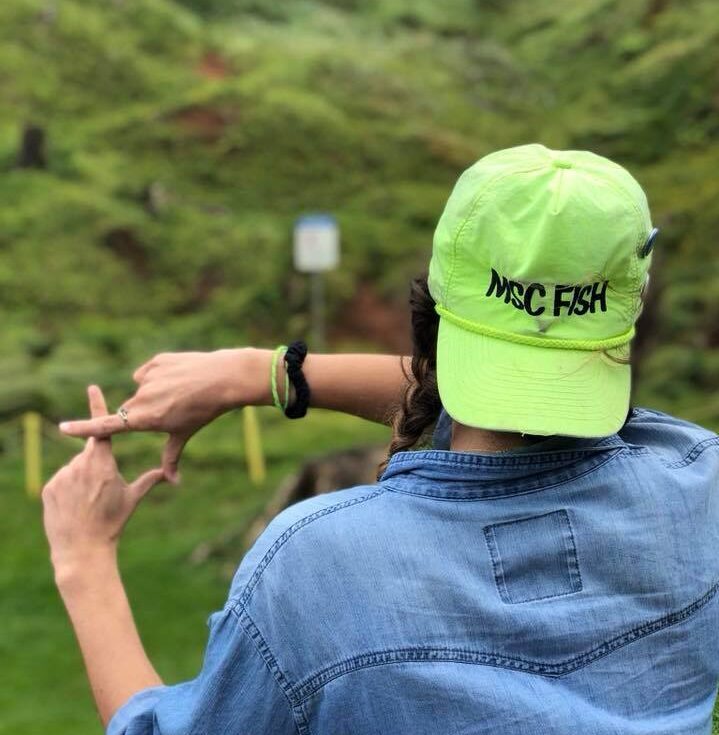 MSC FISH member facing backwards and making the FISH hand sign